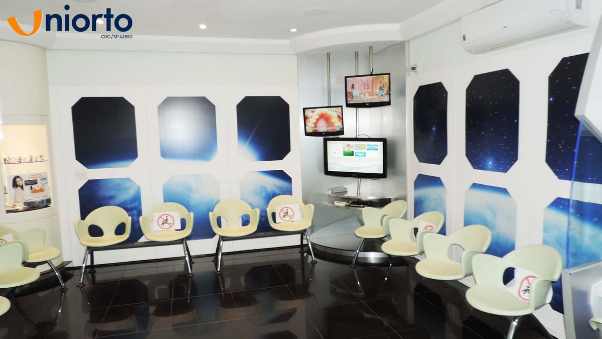 Sala de espera com painéis em formato de escotilha e mural de galáxia nas paredes